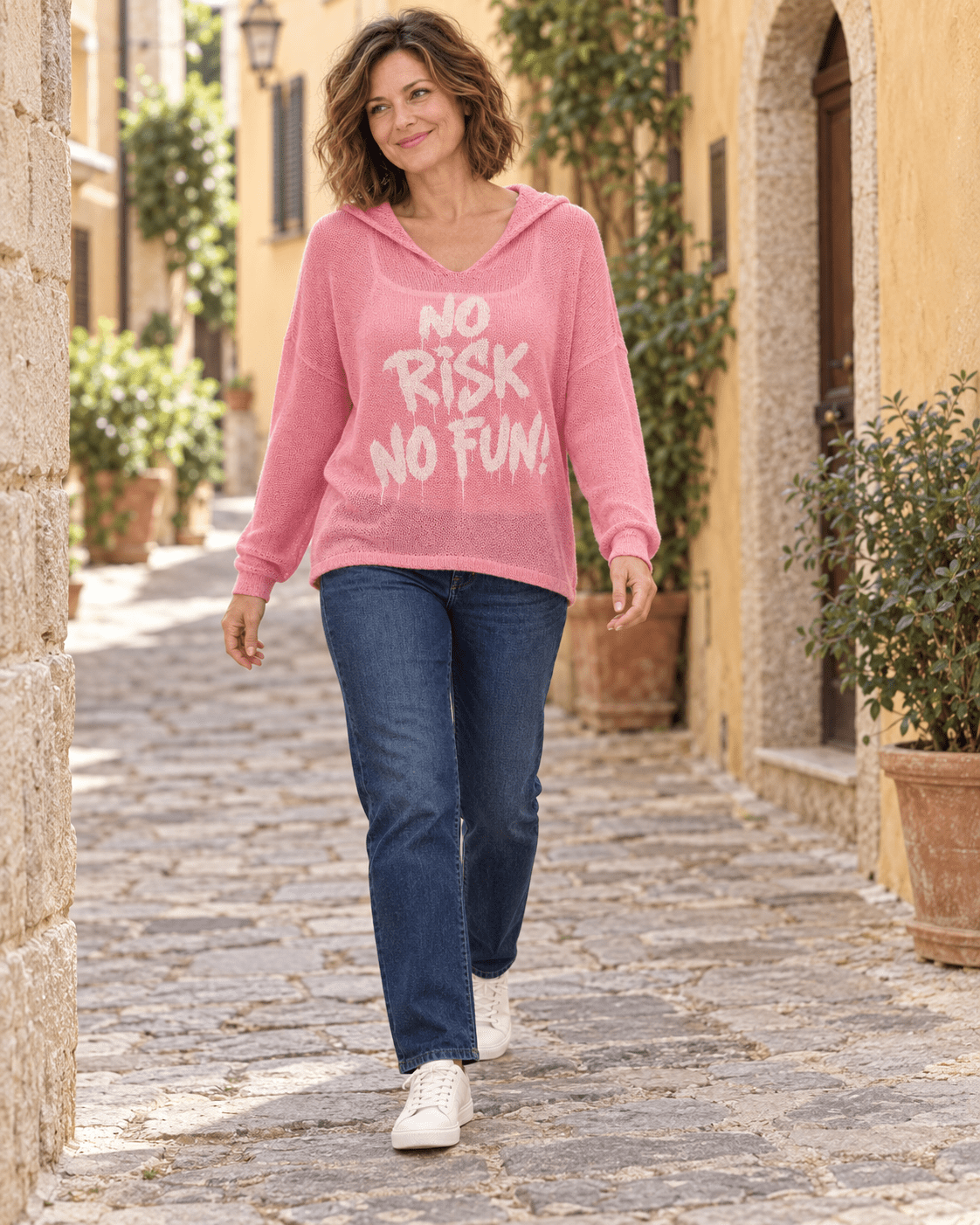 Pull rose No Risk No Fun porté avec un jean et des baskets, silhouette entière