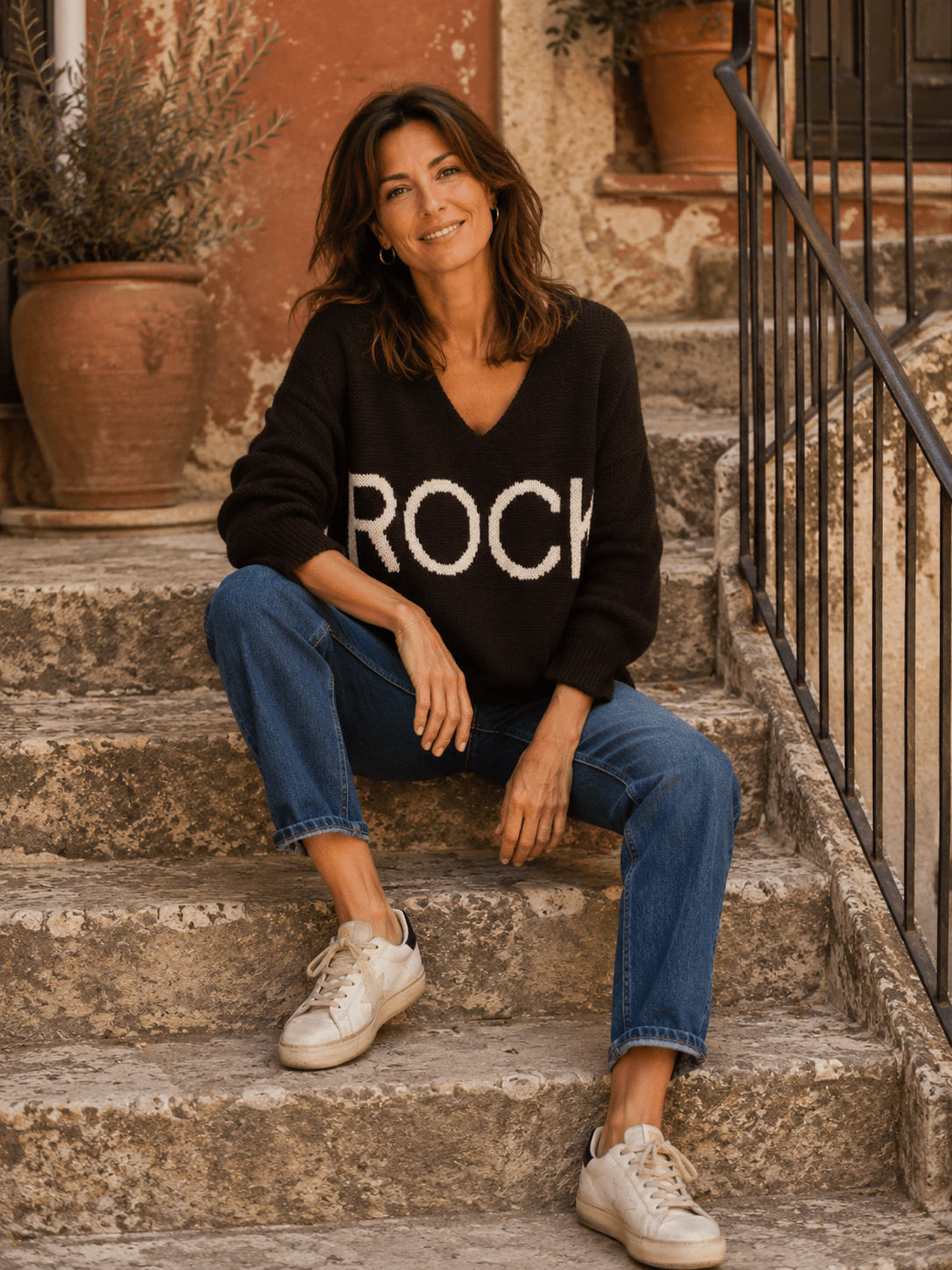 Pull Rock chocolat porté avec jean bleu sur des escaliers italiens
