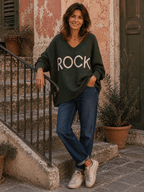 Pull Rock kaki porté avec jean bleu et baskets dans une rue italienne