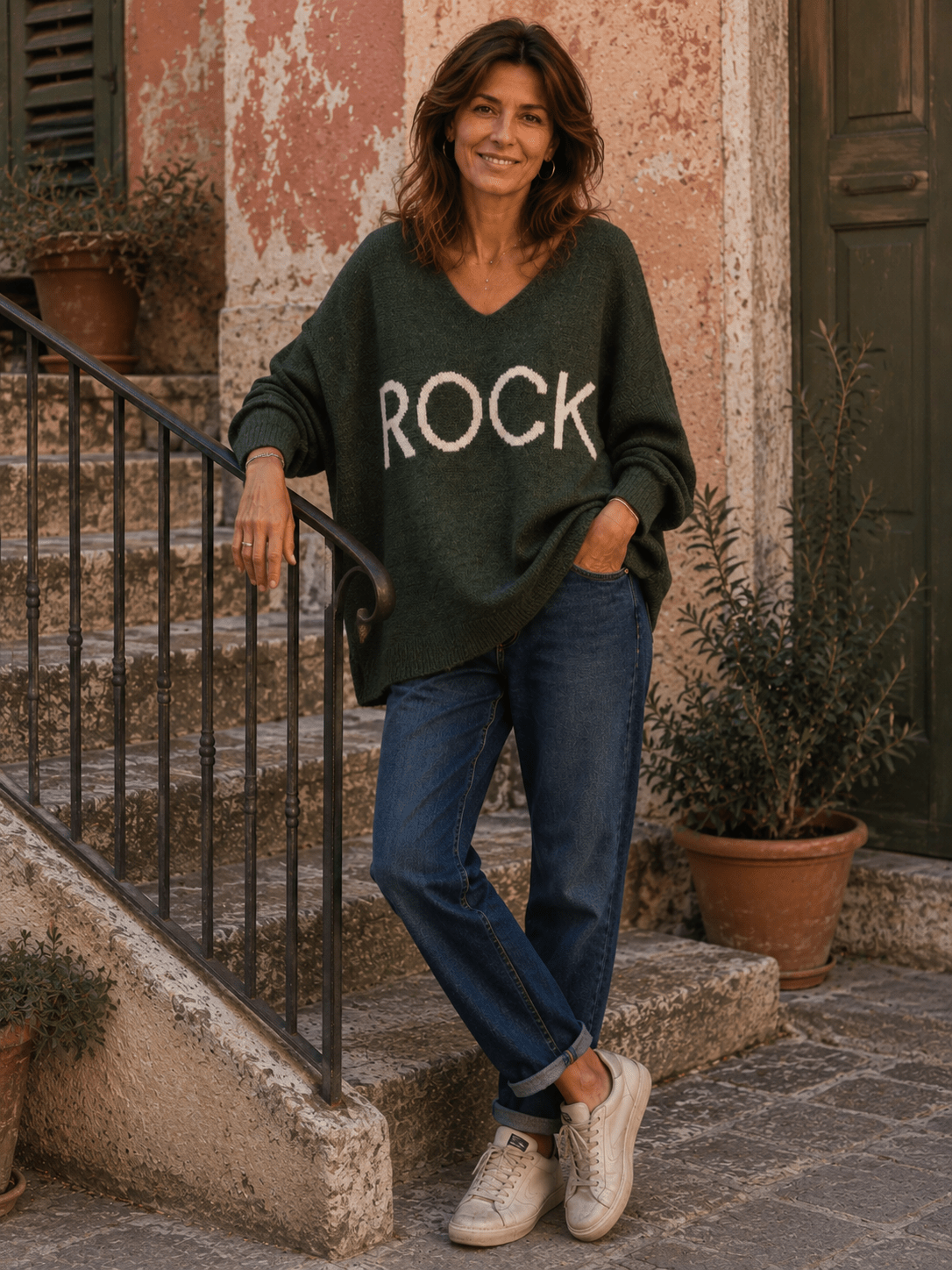 Pull Rock kaki porté avec jean bleu et baskets dans une rue italienne