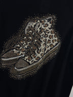 Détail du motif sneakers léopard et des strass du Pull Salerno noir
