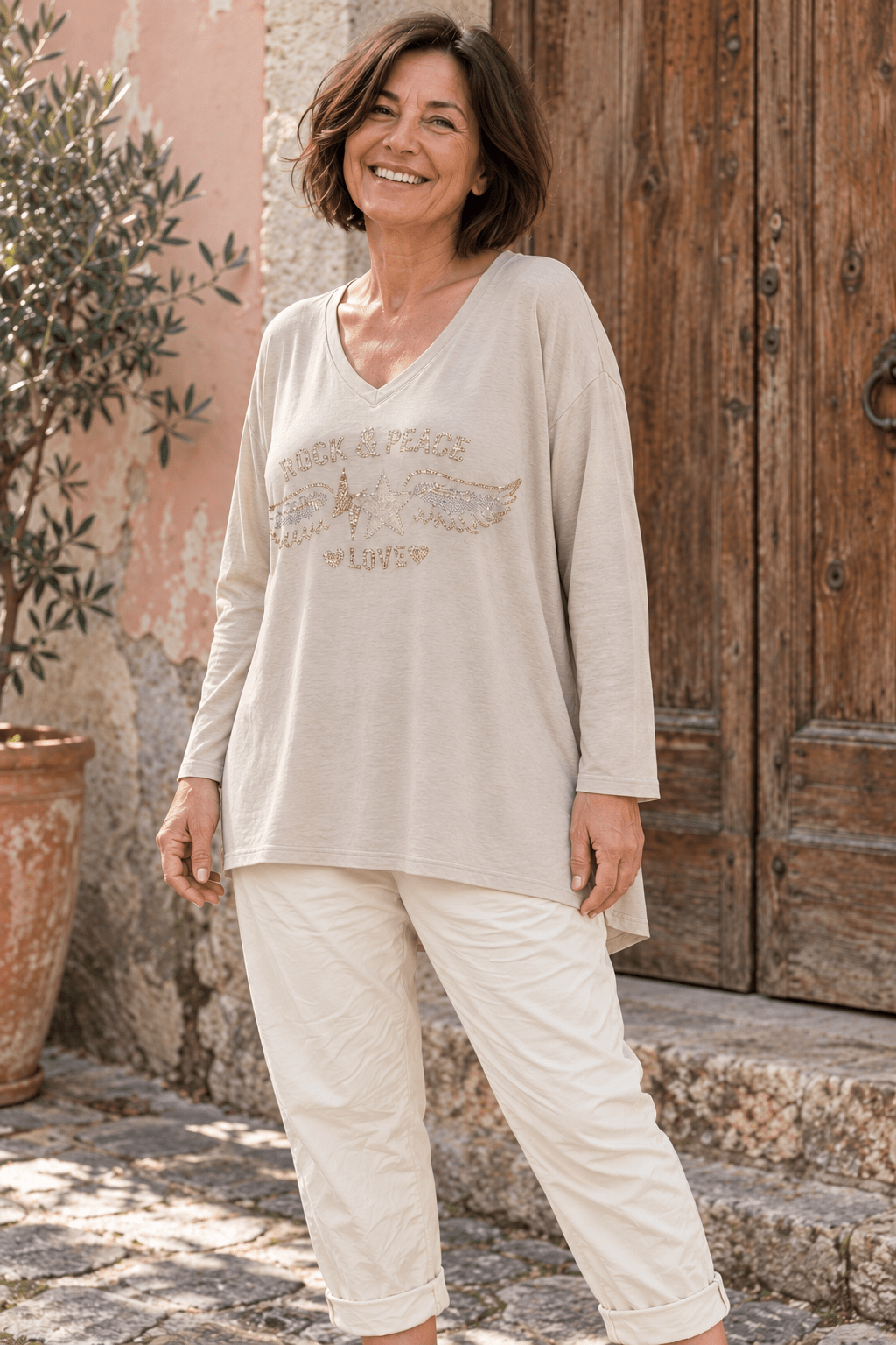 Pull Stella beige porté avec un pantalon magique écru, vue trois-quarts montrant le dos légèrement plus long. (Mise en scène IA.)