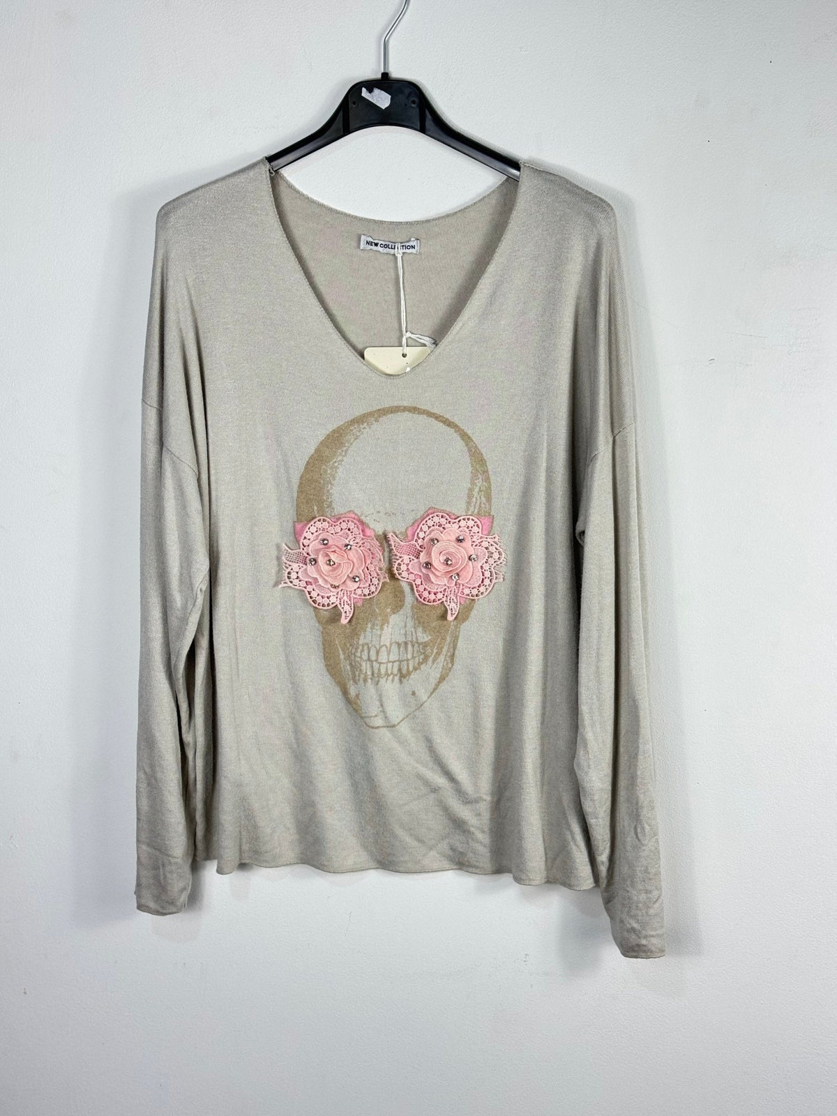 Photo source du pull beige grège avec tête de mort et fleurs roses.
