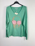 Pull vert à col V, motif tête de mort avec appliqués de fleurs roses.