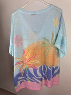 Pull tropical femme bleu ciel avec feuillages colorés et maille scintillante, vue de dos sans motif toucan