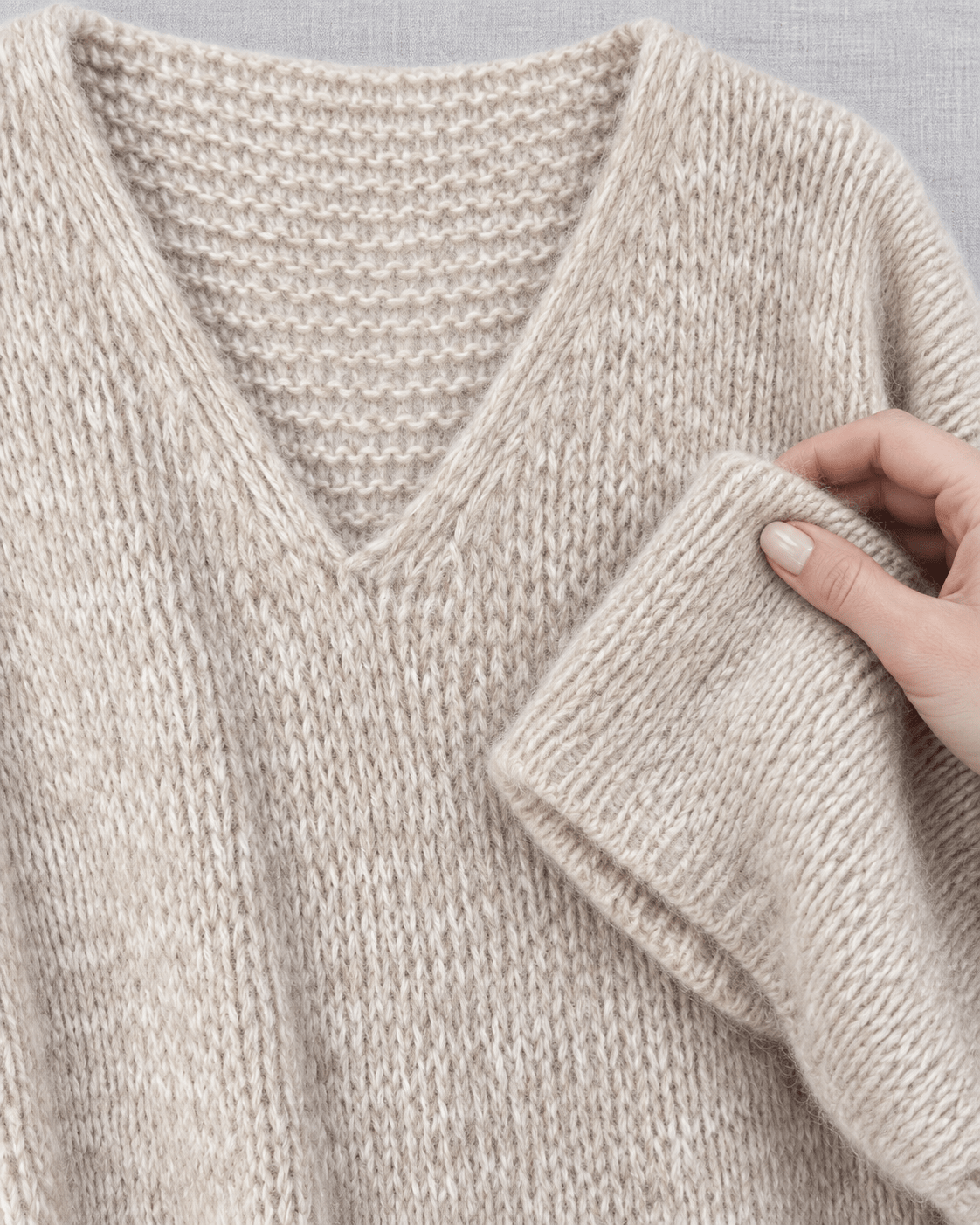 Gros plan de la maille chinée beige et du col V de la robe Cocoon