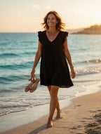 Robe fluide manches volantées noire portée sur la plage, ambiance estivale bohème – Mam's Ailes