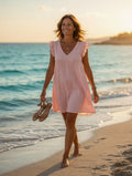 Femme portant la robe fluide manches volantées coloris rose en bord de mer – Mam's Ailes