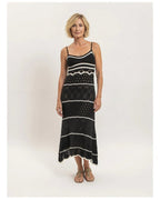 Robe longue Naïa noire en maille ajourée avec fines bretelles et rayures contrastées, vue de face portée avec sandales