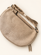 Sac Serpente beige, vue arrière avec sa bandoulière pliée et réglable, photo retouchée sur fond clair.