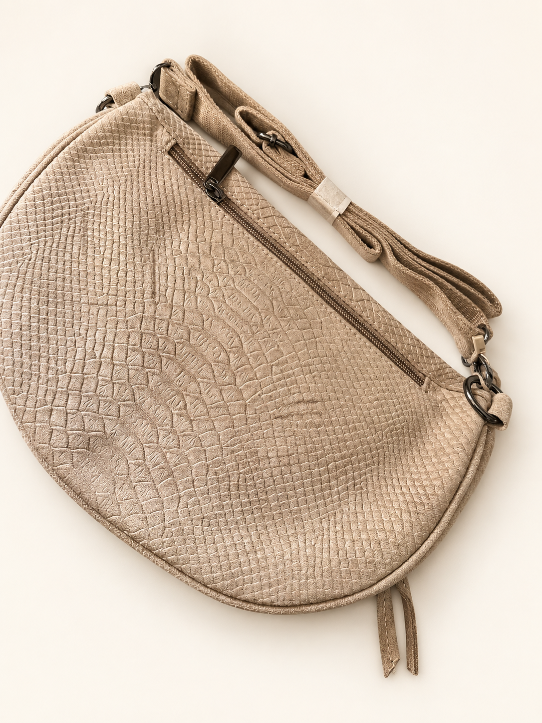 Sac Serpente beige, vue arrière avec sa bandoulière pliée et réglable, photo retouchée sur fond clair.