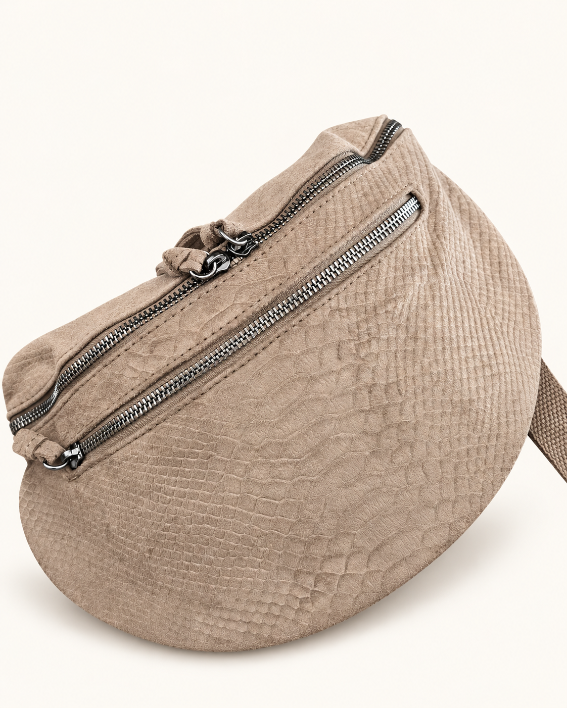 Sac Serpente beige, gros plan du motif serpent et des zips argentés, photo retouchée sur fond clair.