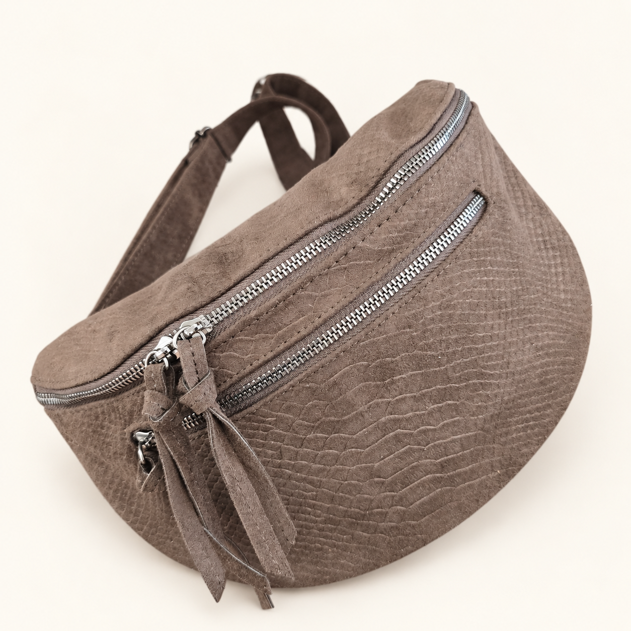 Sac banane Serpente chocolat avec zips argentés et bandoulière assortie, photo retouchée sur fond clair.