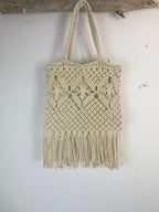 Sac macramé à franges bohème crème accroché sur bois flotté, tressage floral et longues franges – Mam's Ailes