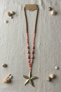Sautoir bohème femme perles bois rose avec pendentif étoile dorée, vue à plat