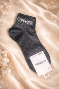 Chaussette noire pailletée avec inscription "Connasse" en blanc – modèle audacieux et chic.