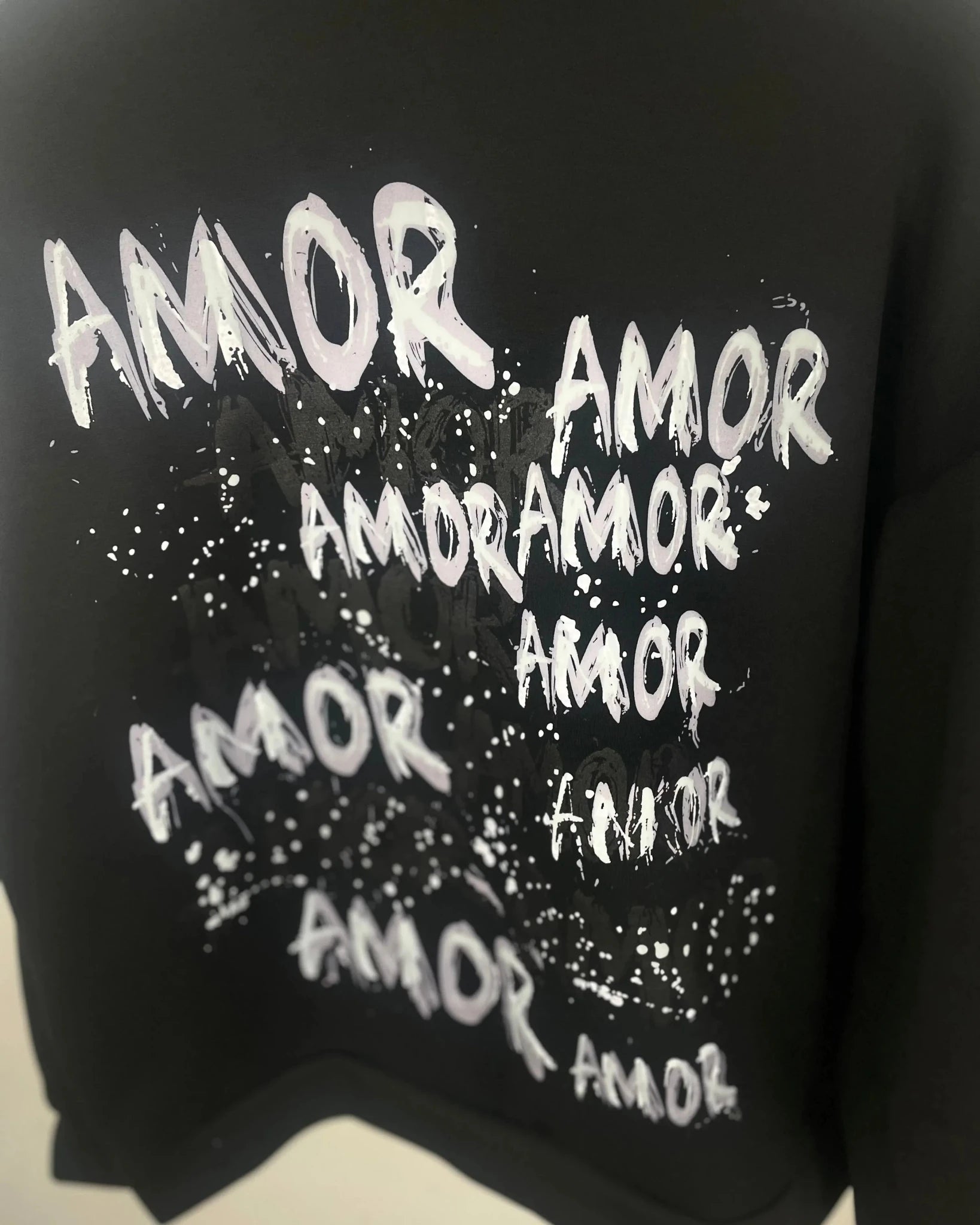 Imprimé AMOR au dos du sweat noir, vue complémentaire