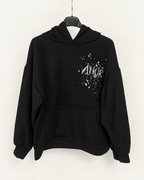 Sweat AMOR noir sur cintre, éclairage et fond harmonisés