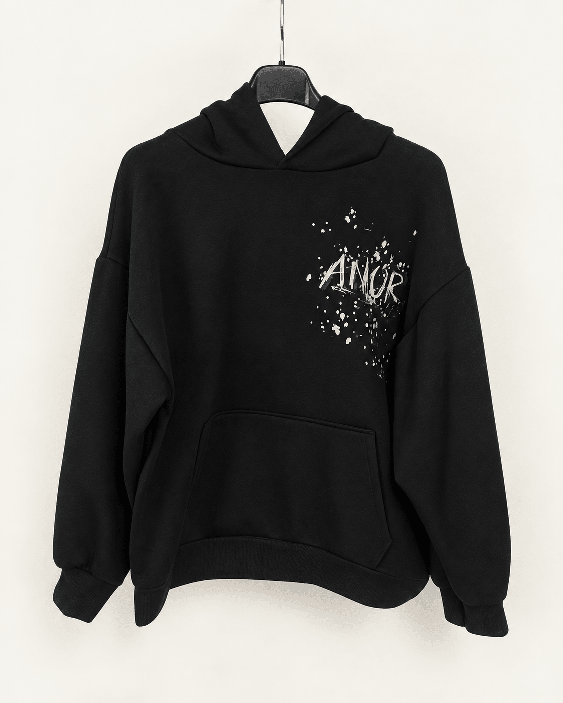 Sweat AMOR noir sur cintre, éclairage et fond harmonisés