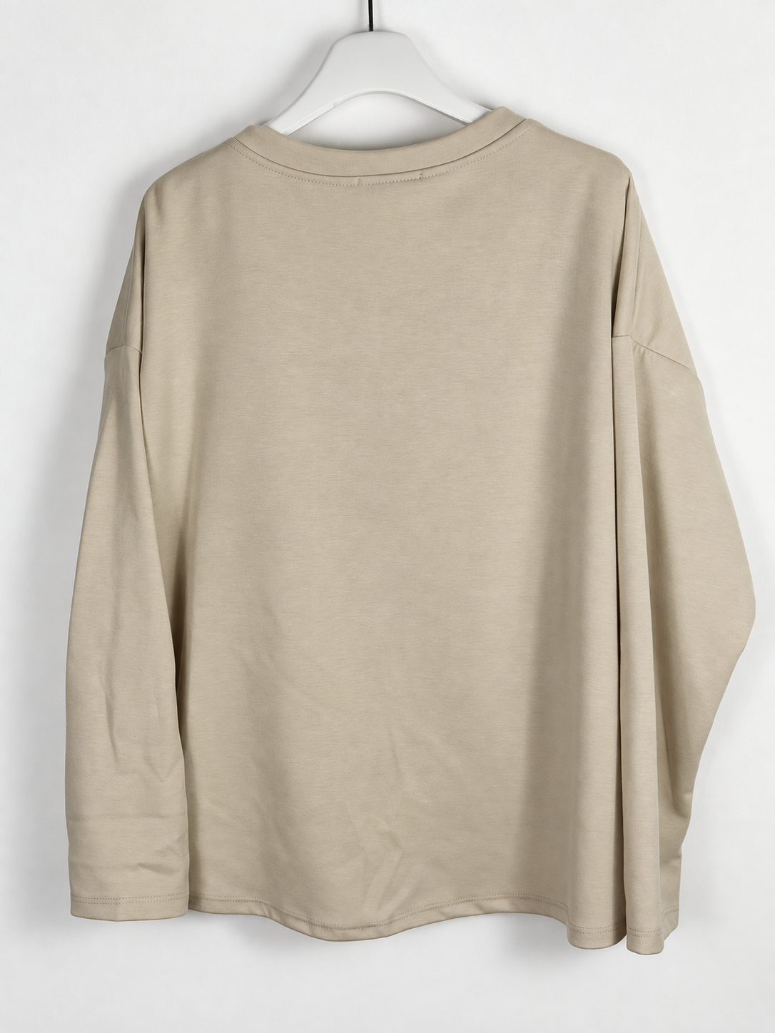 Dos uni du sweat beige sur cintre avec coutures aux épaules descendues, photo retouchée.