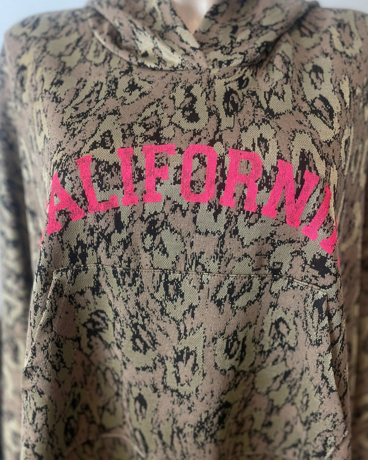 Gros plan sur l’inscription rose fluo CALIFORNIA et la maille à motif