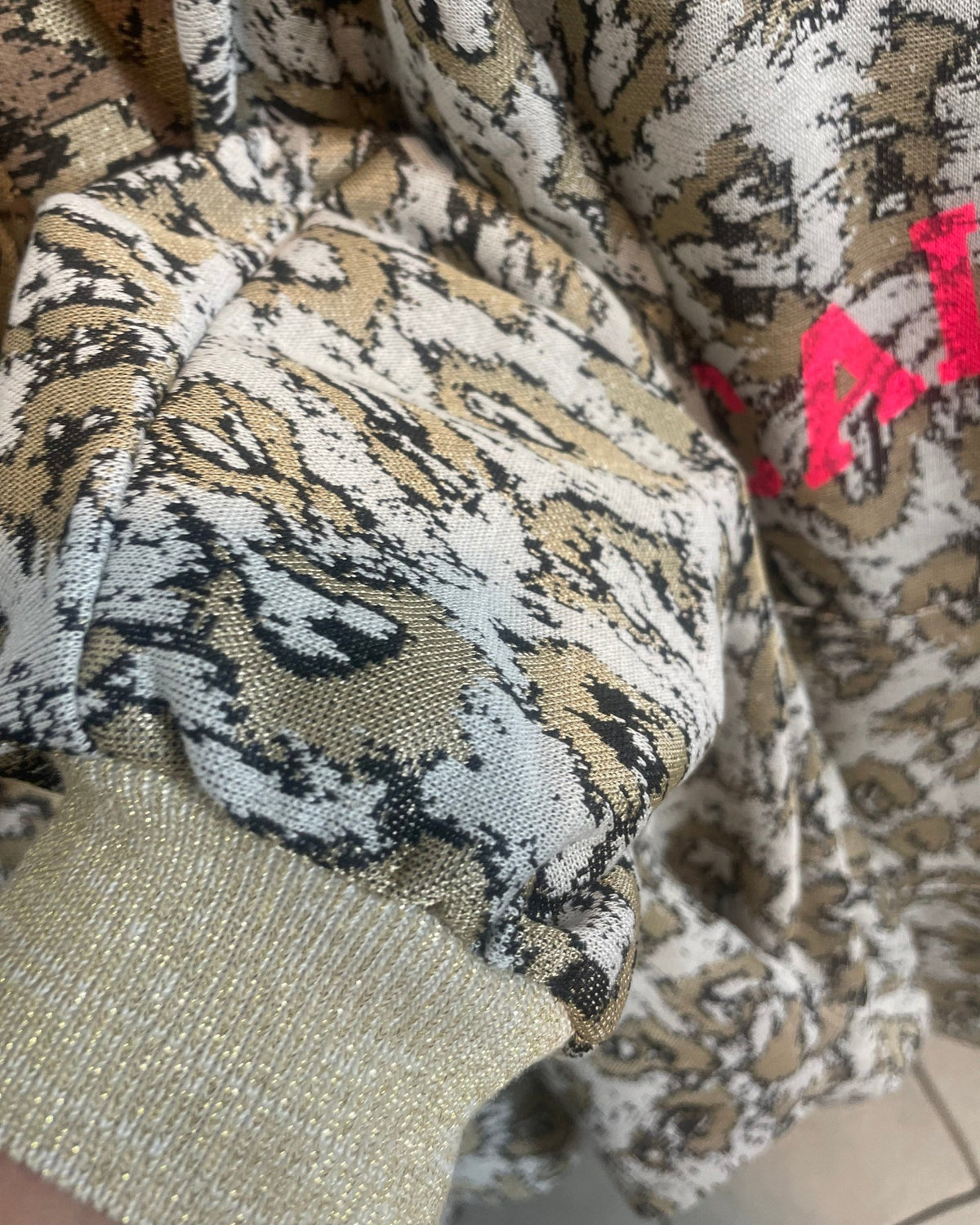 Détail du poignet en maille métallisée dorée du sweat California beige