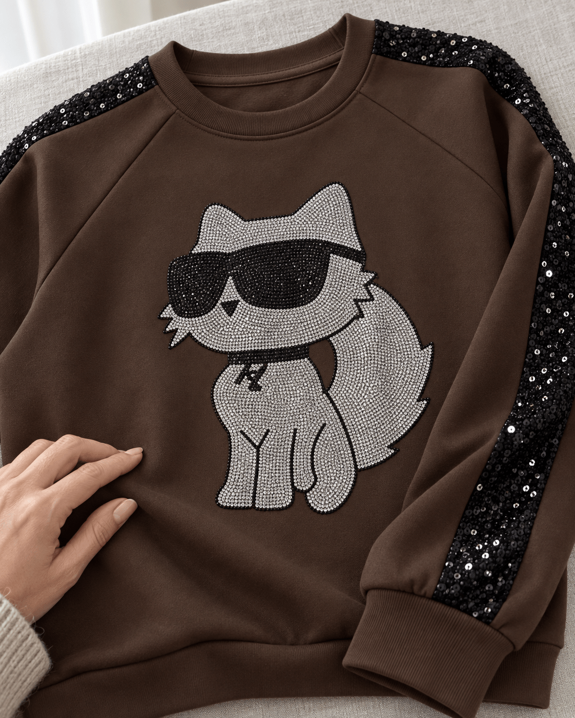 Détail du chat brillant et de la manche à sequins du sweat Catty Chic chocolat