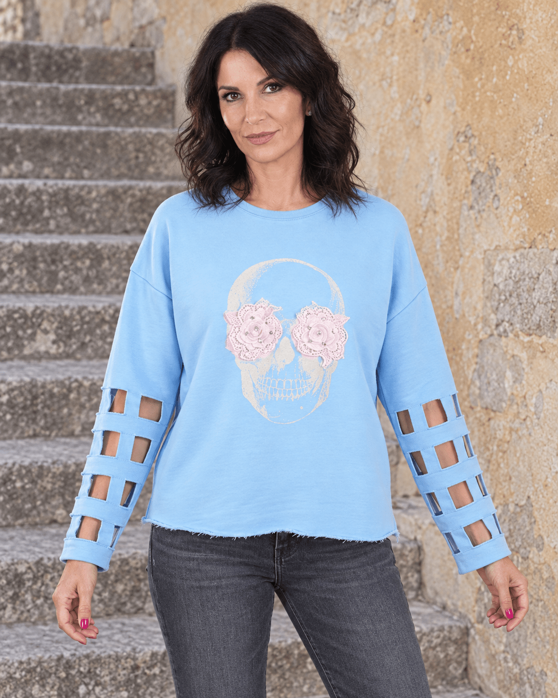 Sweat Crâne Fleuri bleu ciel porté de face, fleurs roses et manches ajourées