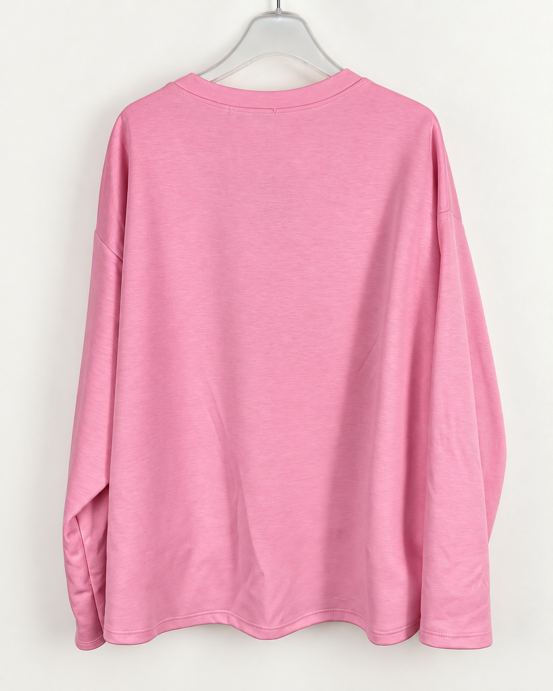 Photo boutique retouchée du dos uni du sweat Instable rose, manches longues et ourlet droit.