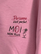 Gros plan original du petit motif côté cœur du sweat rose : Personne n’est parfait… MOI NON PLUS, avec une illustration au miroir.