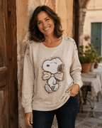 Femme portant le sweat Snoopy beige à strass chocolat dans une ruelle italienne