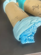 Top dentelle au col et en bas couleur bleu ciel, posé sur une table