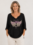 Tee-shirt femme fushia oversize manches longues imprimé Los Angeles et ailes style bohème chic porté par une femme de 50 ans