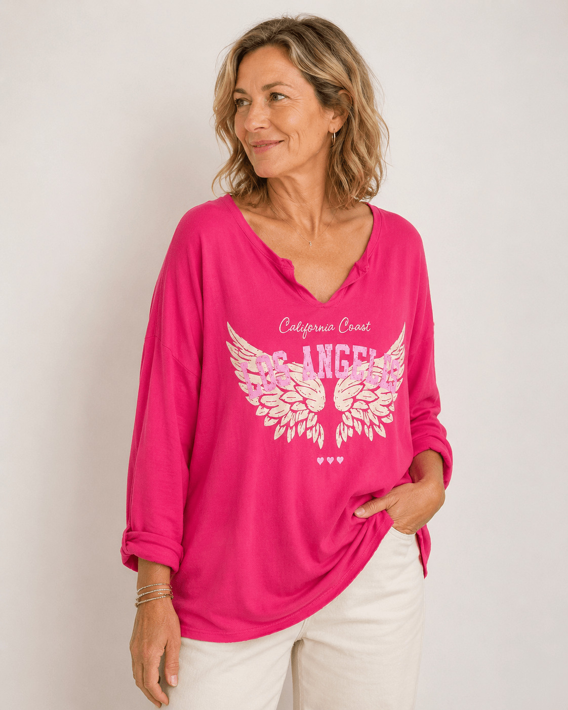 Tee-shirt femme fushia manches longues imprimé Los Angeles ailes blanches porté par une femme naturelle style casual chic