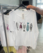 T-shirt blanc femme en voile de coton avec poissons argentés et colorés, vue de face sur cintre