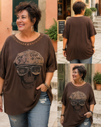 Tee-shirt Rebel chocolat grande taille porté avec motif crâne à casquette graffée et lunettes strass