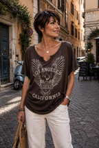 Femme 45 ans cheveux courts effilés portant un tee-shirt chocolat style rock Los Angeles California regard caméra ambiance italienne élégante