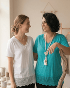 Deux femmes complices portant le top en viscose et dentelle en blanc et turquoise, mode inclusive et naturelle.