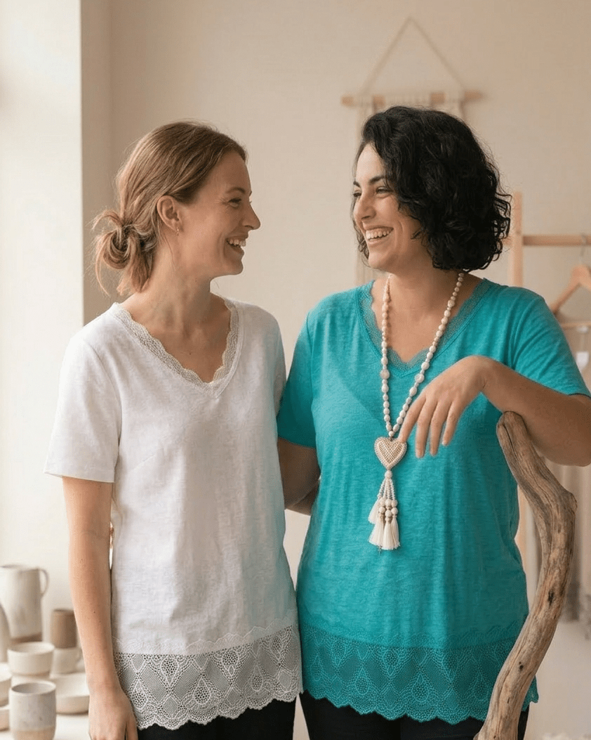 Deux femmes complices portant le top en viscose et dentelle en blanc et turquoise, mode inclusive et naturelle.