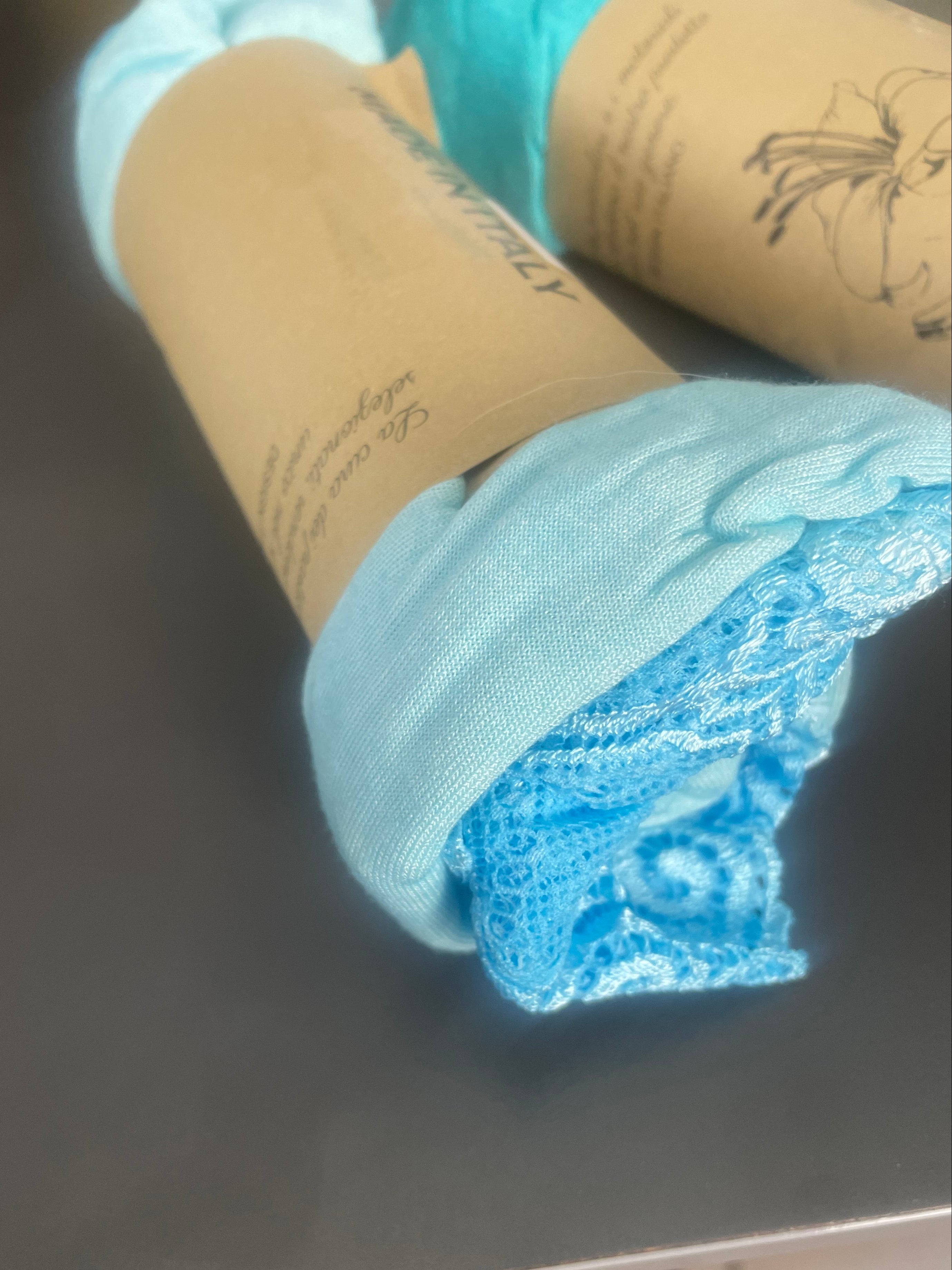 Top dentelle au col et en bas couleur bleu ciel, posé sur une table