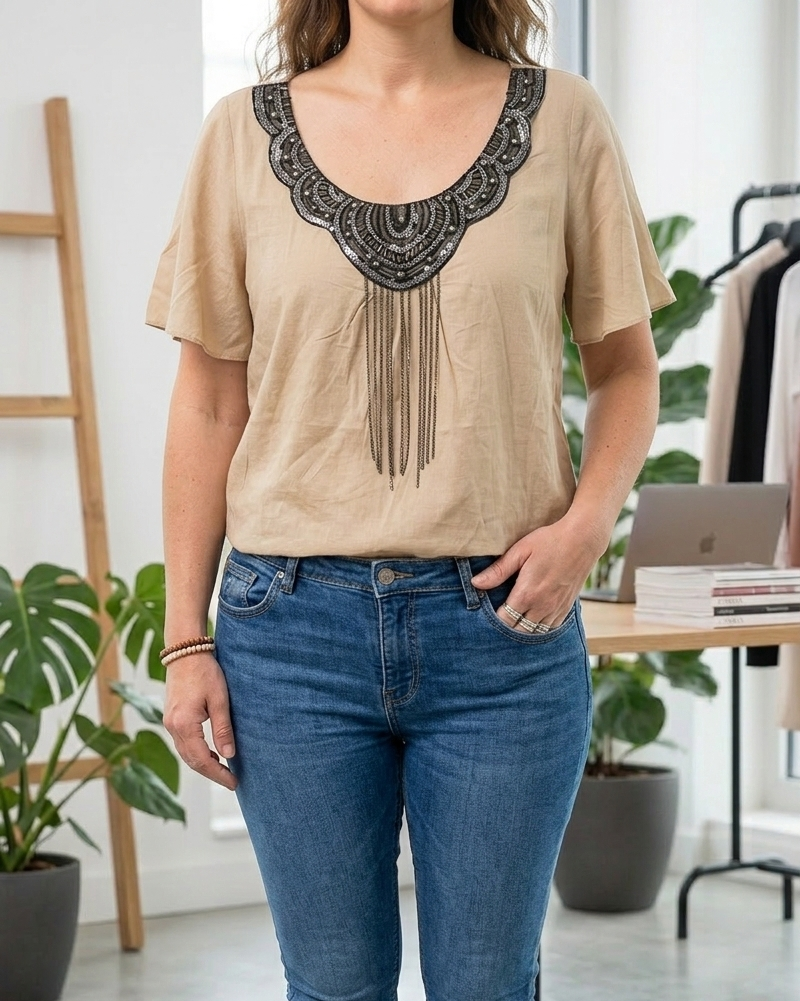 Top bohème chic beige avec franges de chaînettes métalliques et manches courtes amples.
