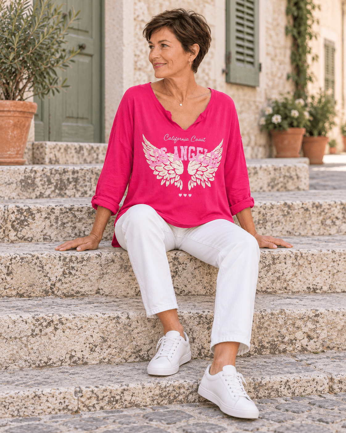 Top Los Angeles fuchsia avec pantalon blanc, silhouette assise sur un escalier