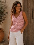 Top maille sans manches rose porté avec pantalon blanc sur femme style bohème chic vue trois quarts