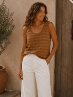 Top maille sans manches camel porté avec pantalon blanc sur femme style bohème chic vue trois quarts