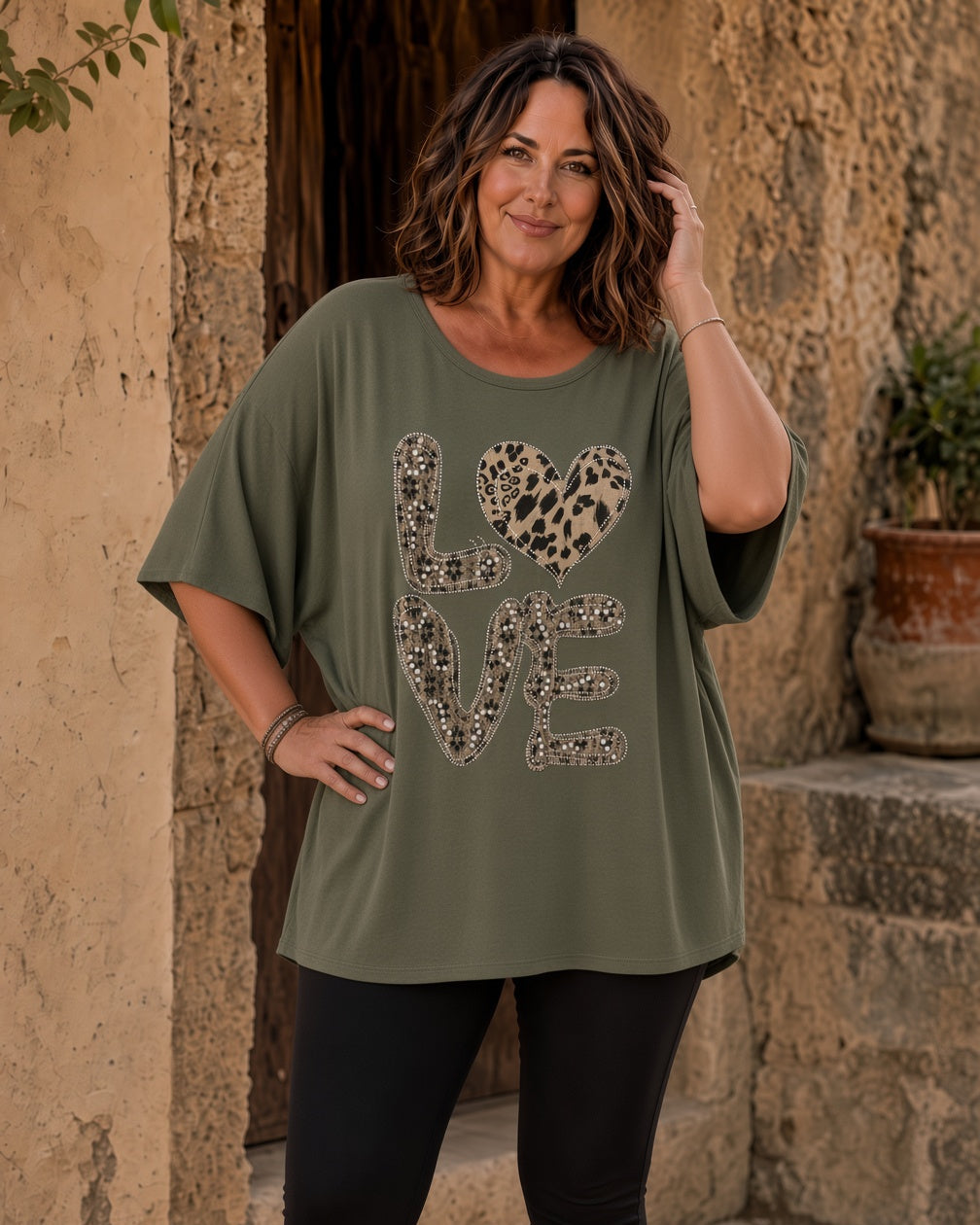 Femme grande taille portant la tunique Amore kaki à motif Love léopard et strass dans une ambiance italienne