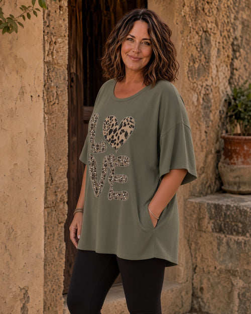 Tunique Amore kaki grande taille portée en extérieur avec grand motif Love léopard et détails strass