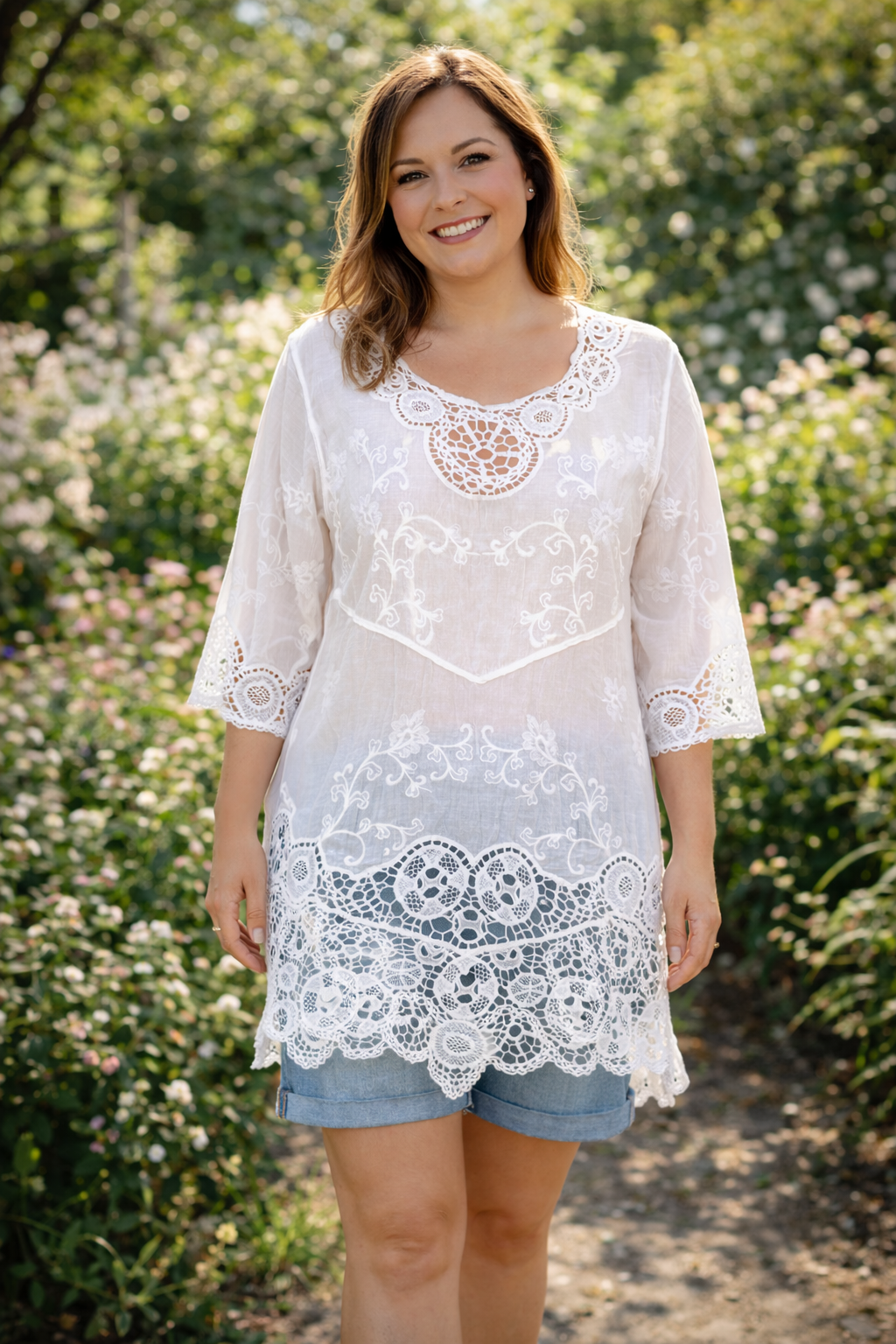 Femme taille 42 portant une tunique bohème blanche en dentelle et broderie avec short en jean clair