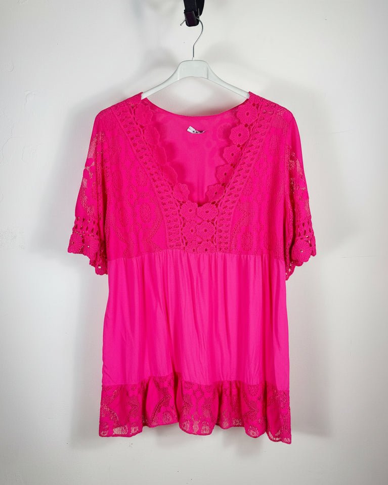 Vue détaillée d’une tunique bohème fushia avec dentelle florale, encolure travaillée et manches crochetées ajourées, style romantique italien pour femme.