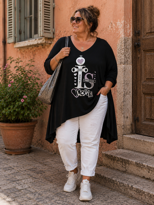 Tunique Queen Good noire portée ample sur une silhouette pulpeuse avec pantalon blanc