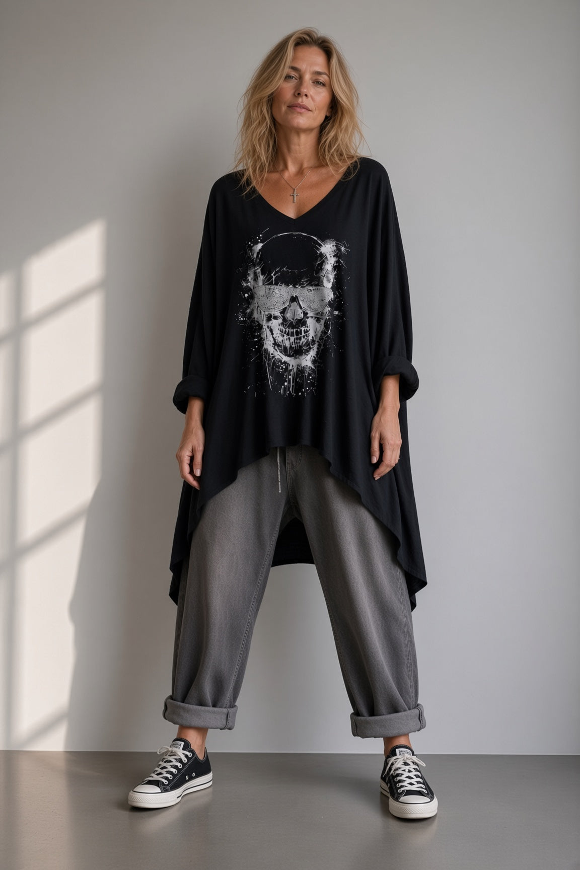 Tunique Rebel noire oversize portée sur une petite silhouette avec pantalon gris